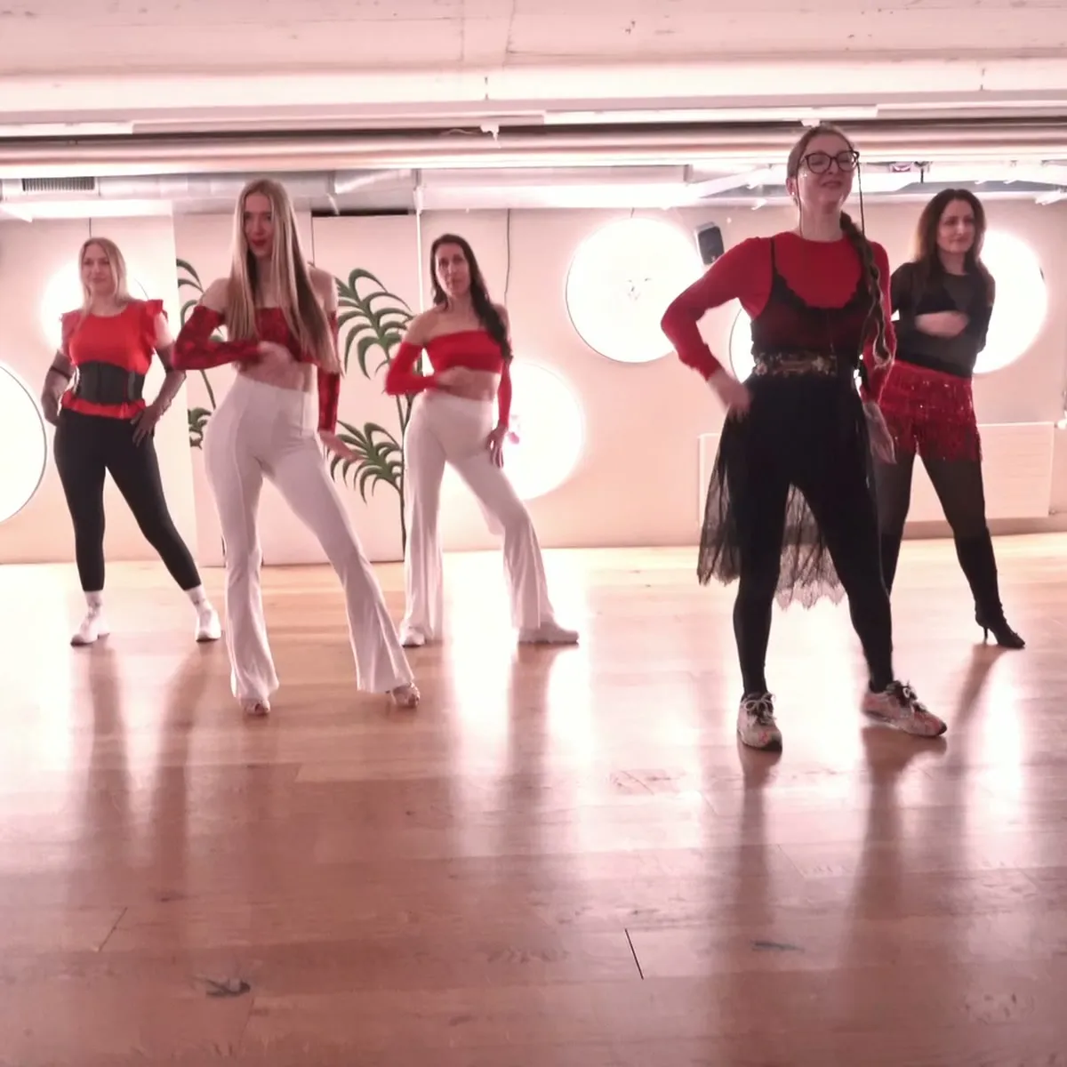 Bachata Solo dancers in red and white holding the last pose of a routine
